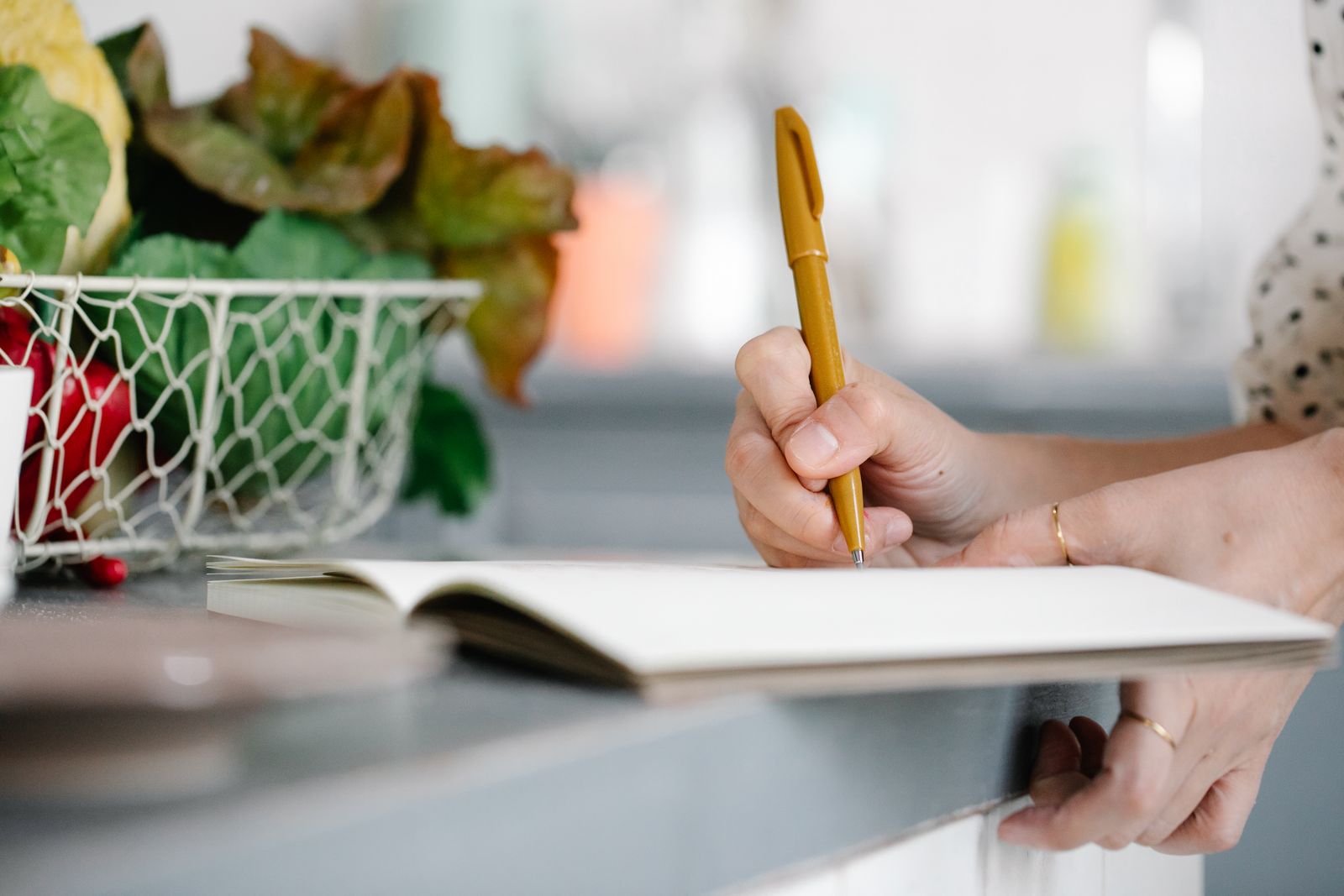 Persona redactando su anuncio intercambio de casa en una mesa de cocina