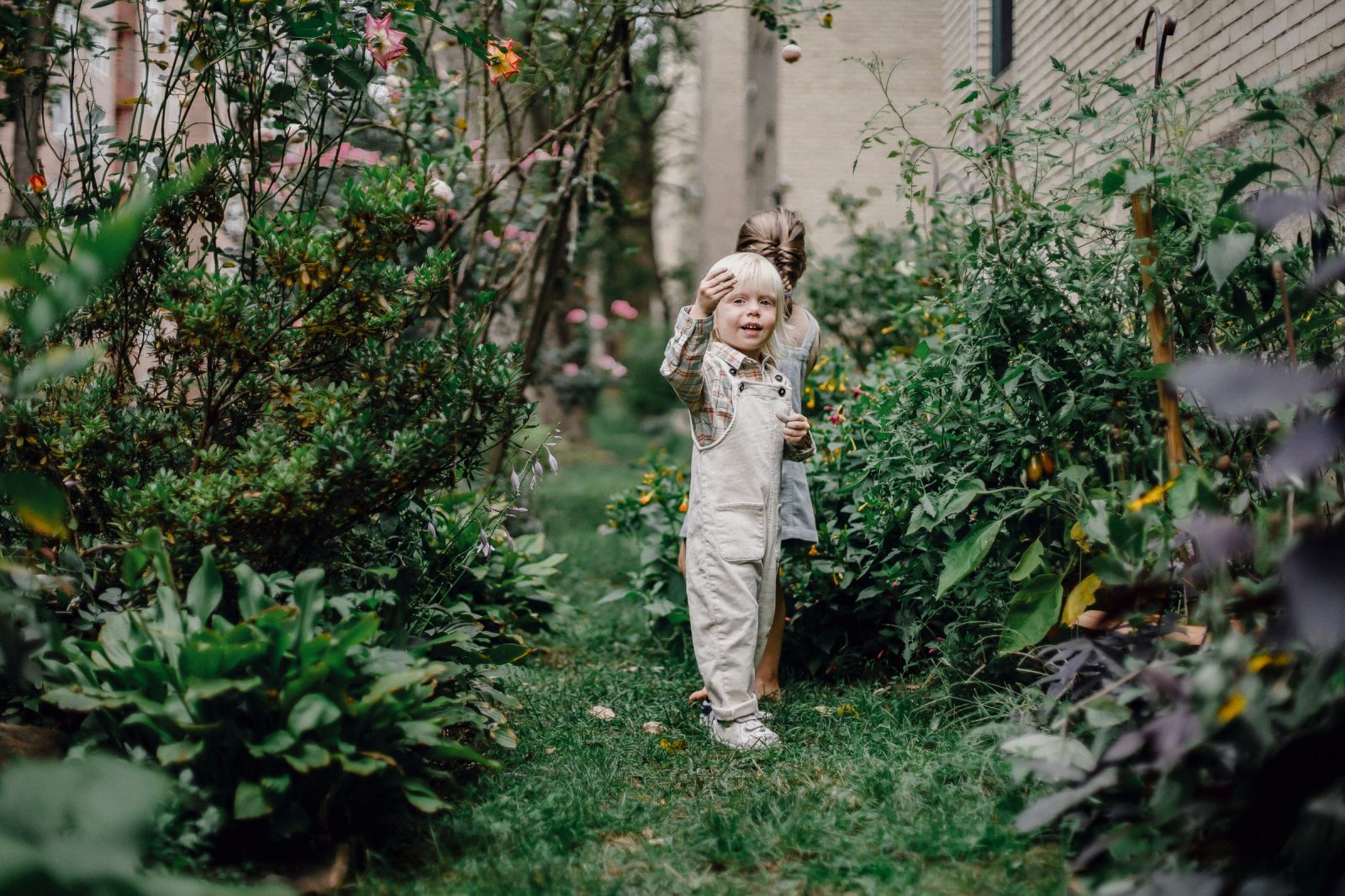 Dos niños juegan en el jardín cerrado de una casa familiar durante un intercambio de vacaciones