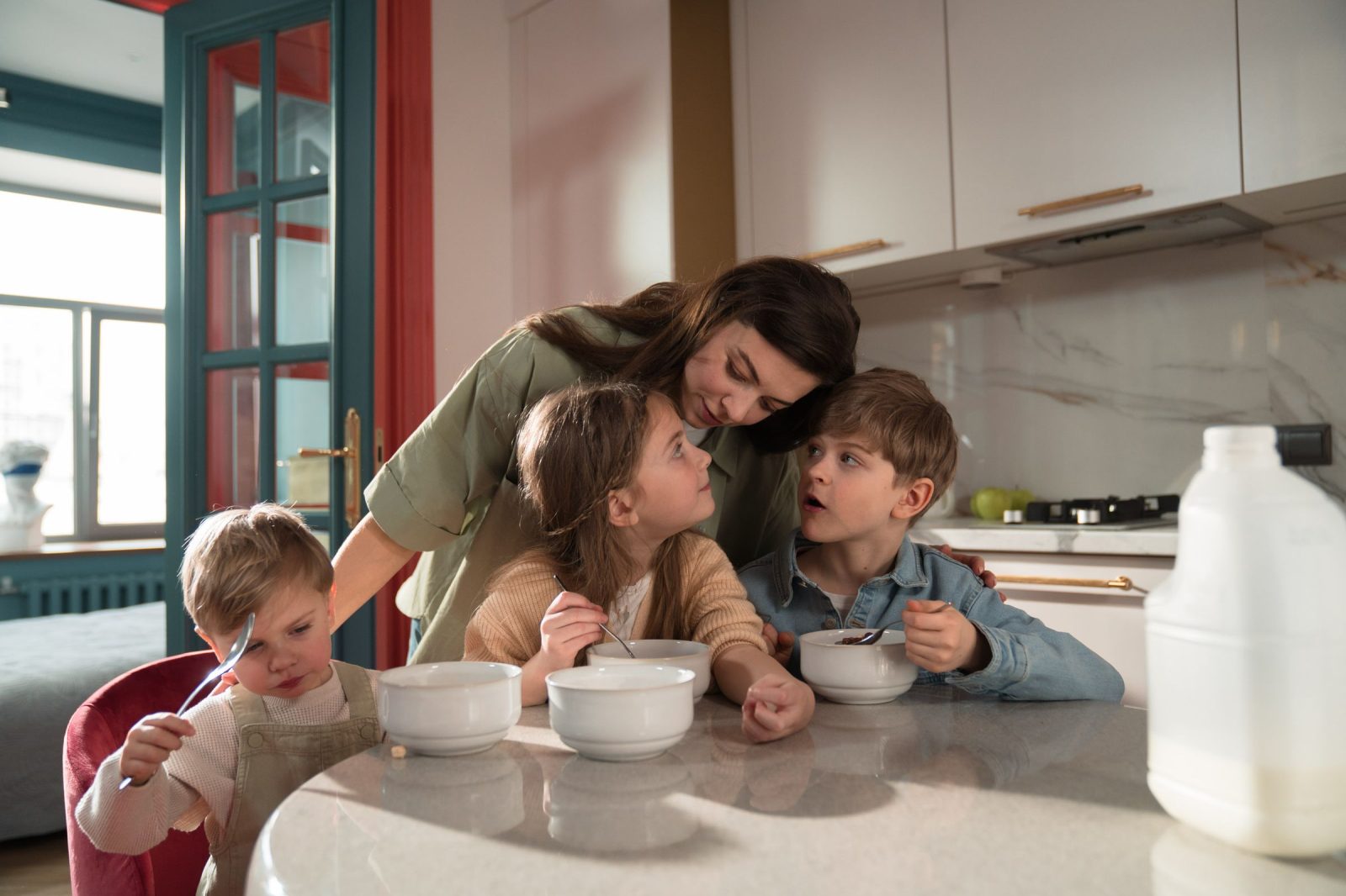 Una madre y sus tres hijos desayunando en la cocina de una casa de intercambio